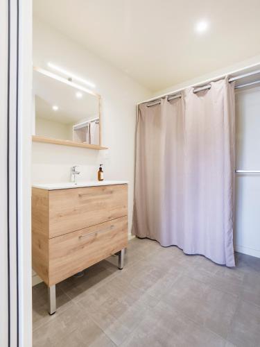 une salle de bain avec un lavabo et un rideau de douche dans l'établissement Ancien Atelier Maison Style & Moderne Guérande, à Guérande
