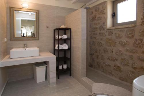 a bathroom with a sink and a mirror at Poliana Estate Villas in Riglia