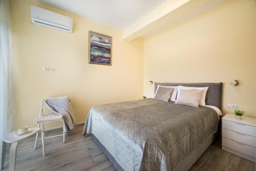 a small bedroom with a bed and a chair at Villa Linz in Tivat
