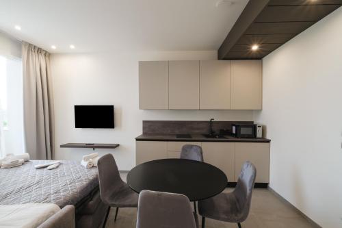 a kitchen and dining room with a table and chairs at Residence Goldoni6 Suite Apartment in Rimini