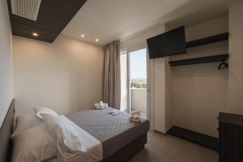 a bedroom with a bed and a large window at Residence Goldoni6 Suite Apartment in Rimini