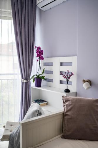 a living room with a window with flowers on a shelf at Villa Linz in Tivat