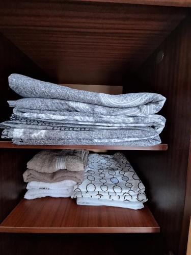 a stack of towels on a wooden shelf at Rovshan's house in Sheki