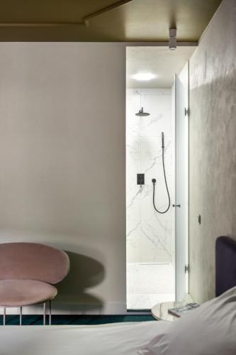 a bedroom with a shower and a bed and a glass door at Vozdvyzhensky Boutique Hotel in Kyiv