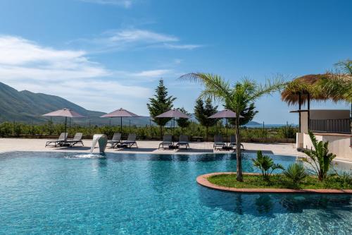 a man is standing in a pool at a resort at Acros Resort in Vlorë