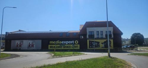 a building with a sign on the side of a road at Arkady House in Olsztynek
