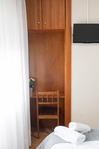 a bedroom with a wooden cabinet and a bed at Pensión A Codeseira Melide in Melide