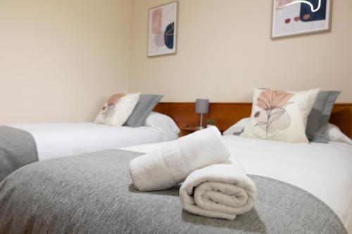 a hotel room with two beds with towels on them at Pensión A Codeseira Melide in Melide