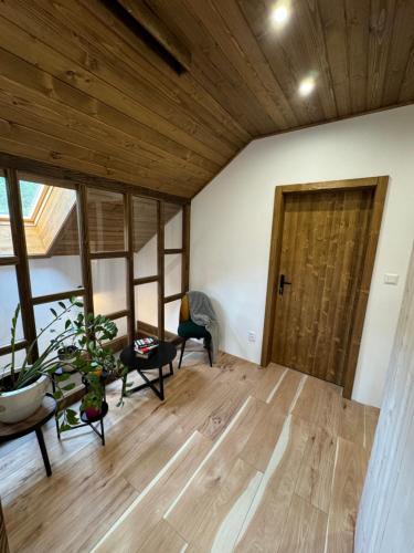 a room with a wooden floor and a wooden door at Chata pod Cigerníkom in Matiašovce