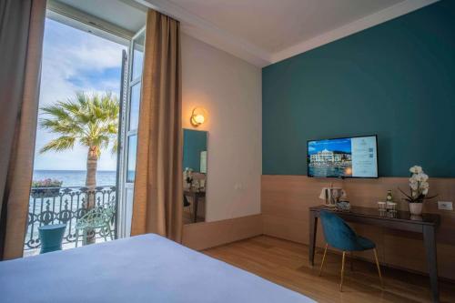 Pokój hotelowy z łóżkiem, biurkiem i oknem w obiekcie Grand Hotel Alassio Beach & Spa Resort - The Leading Hotels of the World w Alassio