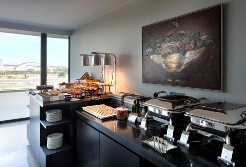 a kitchen with a counter with a counter top with a counter sidx sidx at Eurostars Zaragoza in Zaragoza