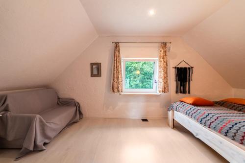 a attic bedroom with a bed and a window at Domek Masuria in Orzysz