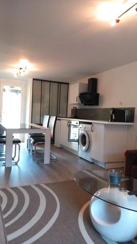 a living room with a table and a kitchen at Appartement 4 personnes in Thizy-les-Bourgs
