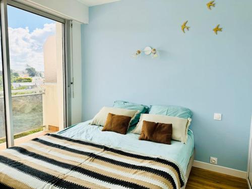 une chambre avec un lit avec une grande fenêtre dans l'établissement L'océan, à Pornichet