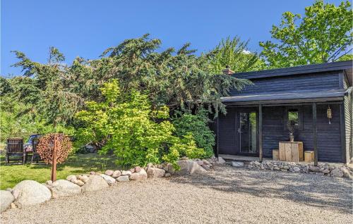 a black house with a gravel yard in front of it at Gorgeous Home In Hasslö With Kitchen in Hasslö