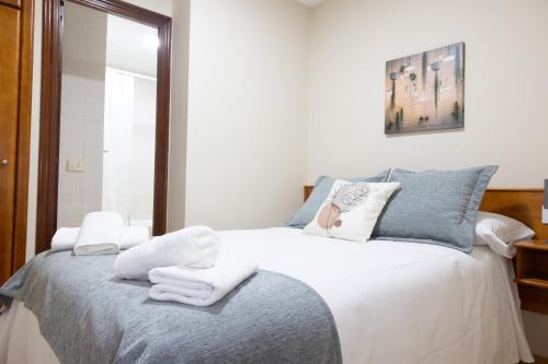 a bedroom with a bed with towels on it at Pensión A Codeseira Melide in Melide