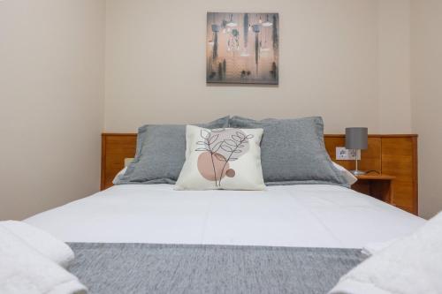 a bed with two pillows on top of it at Pensión A Codeseira Melide in Melide