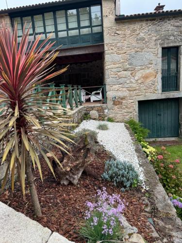 a garden in front of a stone house at Casa de Lela in Negreira