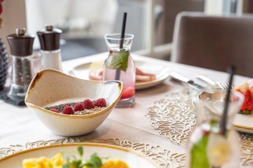 a table with a bowl of food and plates of food at Hotel Schlosswirt in Schenna
