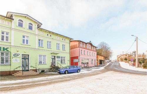 a blue car parked in front of buildings on a street at Three-Bedroom Apartment In Smoldzino in Smołdzino