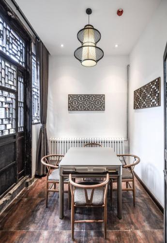 a dining room with a table and chairs at Elsewhere Hotel The former residence of the draft bank in Pingyao