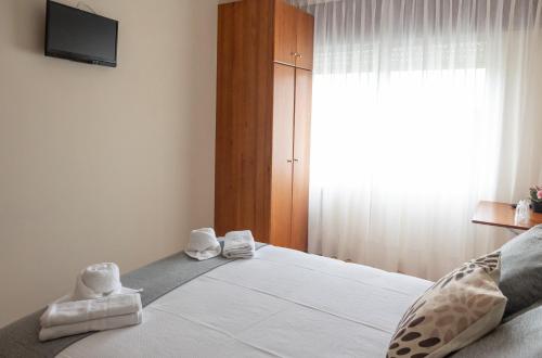 a bedroom with a bed with towels on it at Pensión A Codeseira Melide in Melide