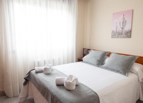 a bedroom with a bed with towels on it at Pensión A Codeseira Melide in Melide