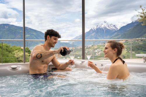 a man and a woman in a bath tub at Hotel Schlosswirt in Schenna