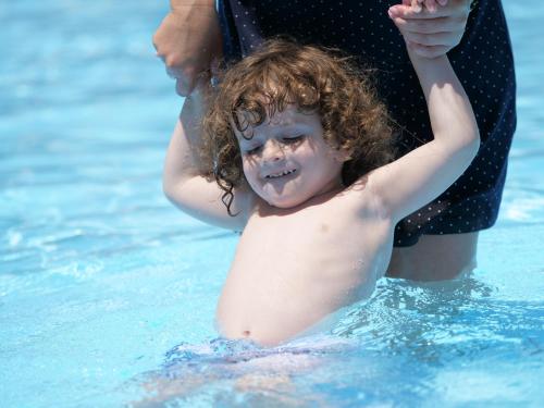 a young child standing in the water in a pool at Nia Boutique Hotel by Rapo's Resort in Himare