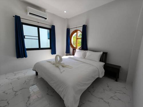 a bedroom with a white bed and a window at Waan Samui Pool Villa in Taling Ngam Beach