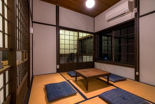 a room with a table and two windows at NIPPONIA Sado 佐渡相川 金山町 in Sado