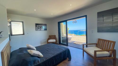 une chambre avec un lit et une vue sur l'océan dans l'établissement Villa Caramontinu, à Sainte-Lucie de Porto-Vecchio