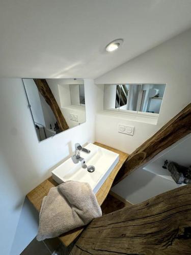 une salle de bain avec un lavabo et deux miroirs dans l'établissement L'Épicerie de Bezenac, à Bézenac