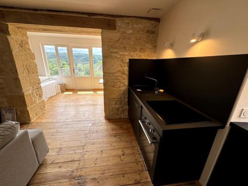 a kitchen with a black counter and a wooden floor at L'Épicerie de Bezenac in Bézenac
