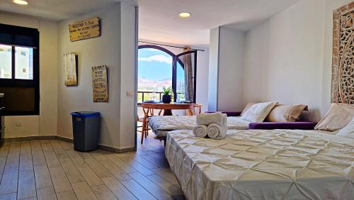 a bedroom with a bed and a couch and a table at Parque Santiago II - Air Conditioning - Ocean View - 350mt from the beach in Playa de las Americas