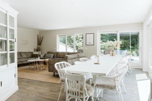 a living room with a white table and chairs at West Nieuwlandseweg 25A - Ouddorp - Poolvilla Zilt & Zoet in Ouddorp