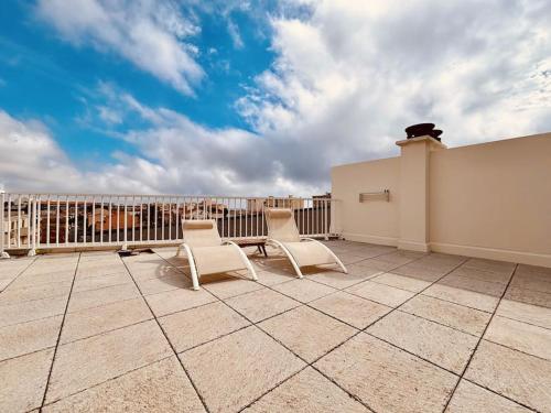 un patio avec deux chaises et une clôture sur un balcon dans l'établissement Magnifique appartement terrasse -36-, à Canet
