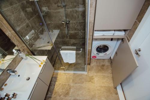 a bathroom with a shower and a washing machine at My Sunshine Apartments in Batumi in Batumi
