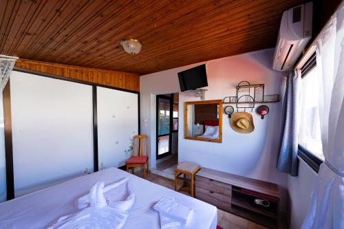 a bedroom with a bed and a large window at Dionisos Roses in Paralia Dionysiou