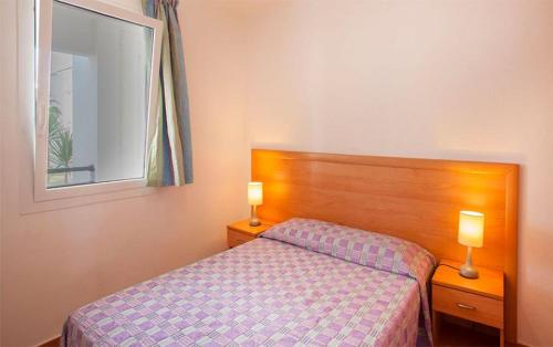 - une chambre avec un lit et deux lampes sur les tables dans l'établissement Appartement en Corse les pieds dans l'eau, à San-Nicolao