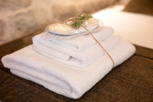 a stack of white towels on a table with a glass jar at Il Trullo di Mariangela in Ceglie Messapica