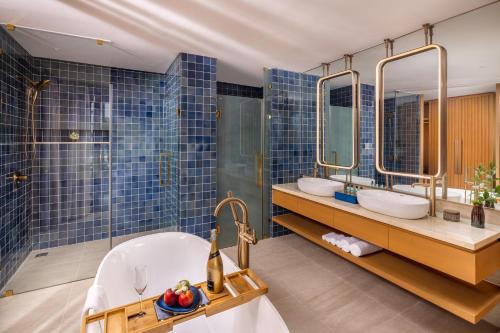 a bathroom with two sinks and two mirrors at Wyndham Hoi An Royal Beachfront Resort & Villas in Hoi An