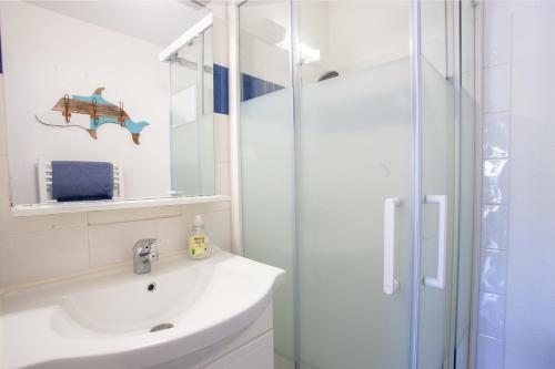 une salle de bain blanche avec un lavabo et une douche dans l'établissement Lou Estrella - Appt 4p avec piscine proche plage, au Lavandou