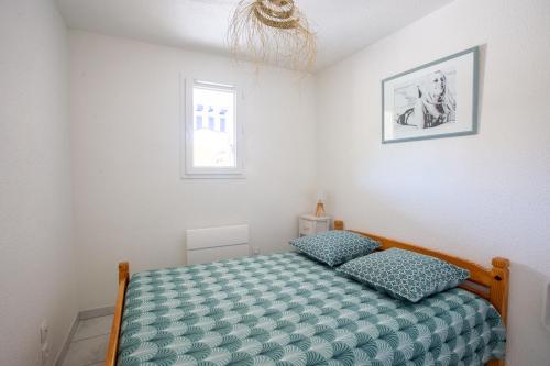 une petite chambre avec un lit et une fenêtre dans l'établissement Lou Estrella - Appt 4p avec piscine proche plage, au Lavandou