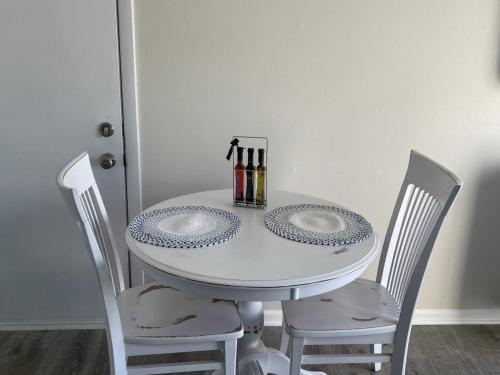 a white table with two plates on it with two chairs at The Shores in Williamsburg