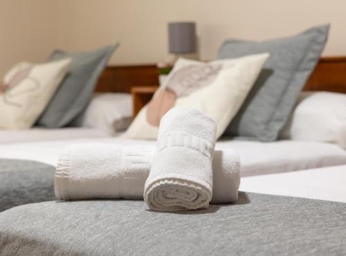 a pile of towels sitting on top of a bed at Pensión A Codeseira Melide in Melide