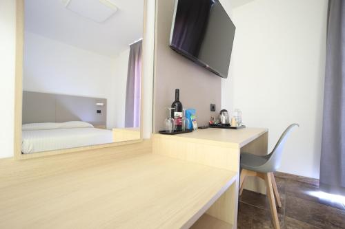 a room with a desk with a mirror and a bed at Tiby Hotel in Modena