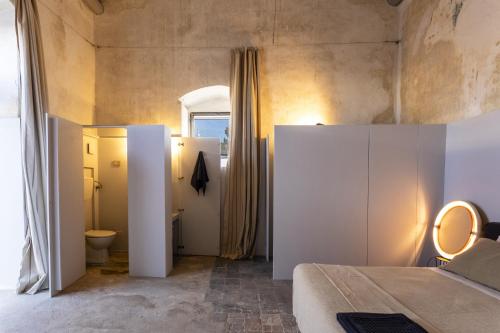 a bedroom with a bed and a toilet in a room at Casa Sisti - IsulaTravel in Rosolini