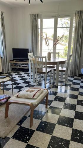 - un salon avec une table et des chaises sur un sol en damier dans l'établissement Villa proche Anse Magaud, à La Garde