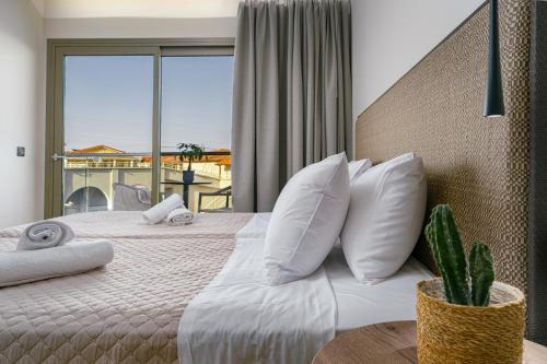 a bedroom with a large bed with a large window at Hotel Papillon in Argasi